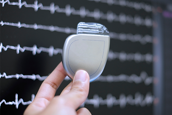 A hand holding a defibrillator device